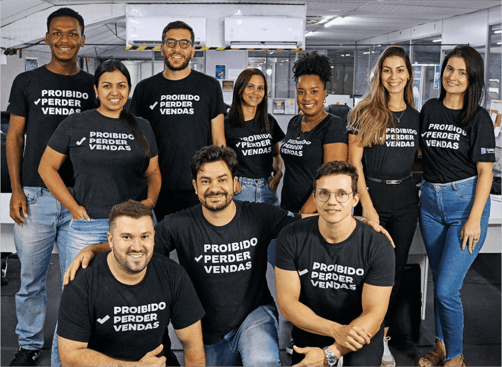 Nas instalações da Yguaçú Máquinas, a equipe de vendas da da mesma, composta por dez pessoas sendo cinco homens e cinco mulheres, todos usando a camiseta com o brasão: Proibido perder vendas!